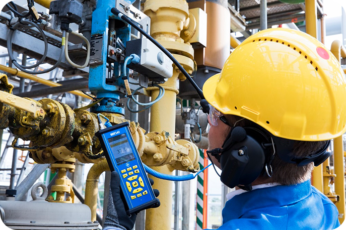 Technician using SDT340 ultrasonic detector to locate compressed air leaks in an industrial facility.