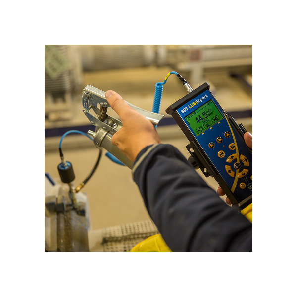 Technician using SDT LUBExpert to apply grease with ultrasound-guided precision.