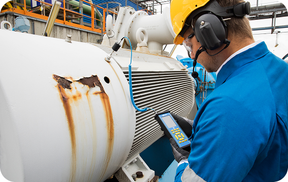 SDT Helps You Make Sense of the Sound Technician inspecting a large industrial compressor with an SDT340 ultrasonic instrument to assess bearing wear.