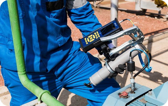 Technician using SDT340 ultrasound data collector with RS2T sensor to monitor bearing lubrication on machinery.