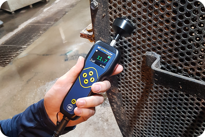 ULTRAChecker Asset Monitoring Applications Technician measuring ultrasound signal on heat exchanger grille using ULTRAChecker.